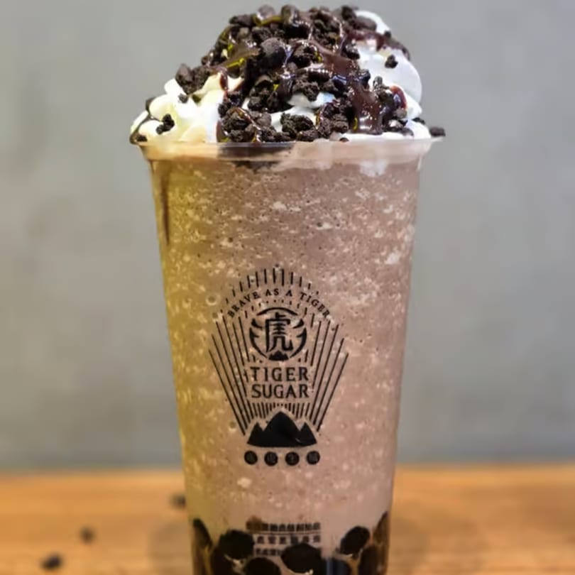 Tiger Sugar chocolate boba drink with whipped cream, chocolate drizzle, and cookie crumbles.